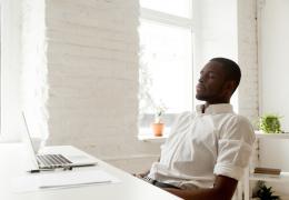 a man sitting at a desk breaking deeply