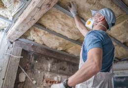 home technician inspecting old insulation