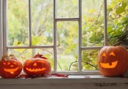 autumn leaves through window of home with carved pumpkins