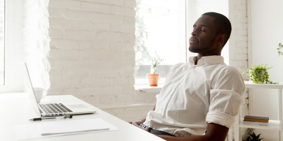 a man sitting at a desk breaking deeply