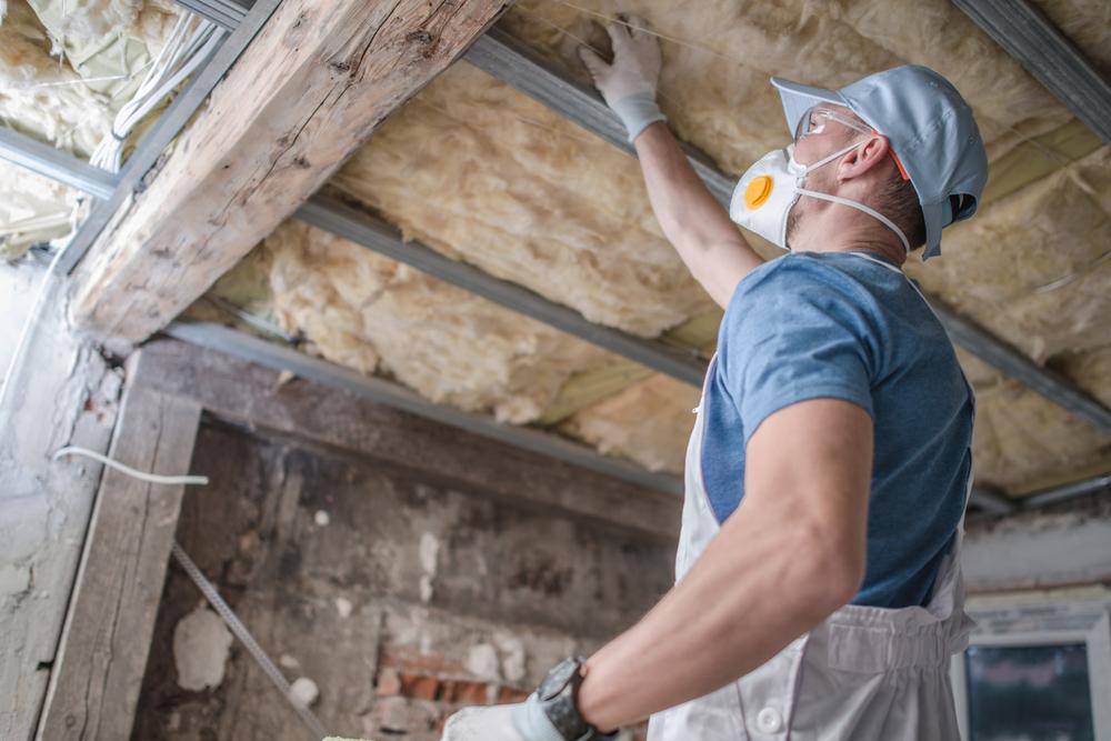 home technician inspecting old insulation home technician inspecting old insulation